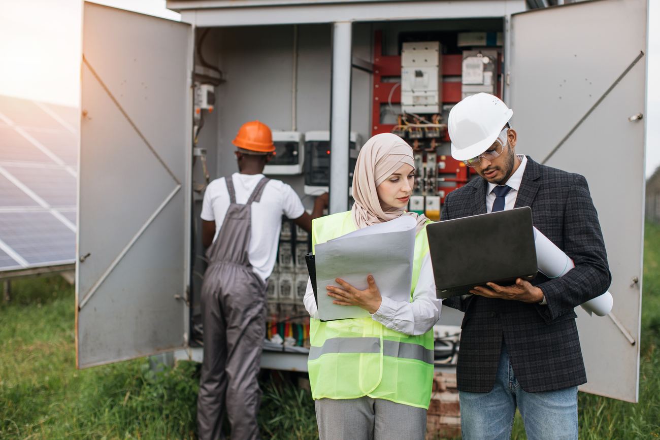 Solar panel technicians inspecting an electrical board